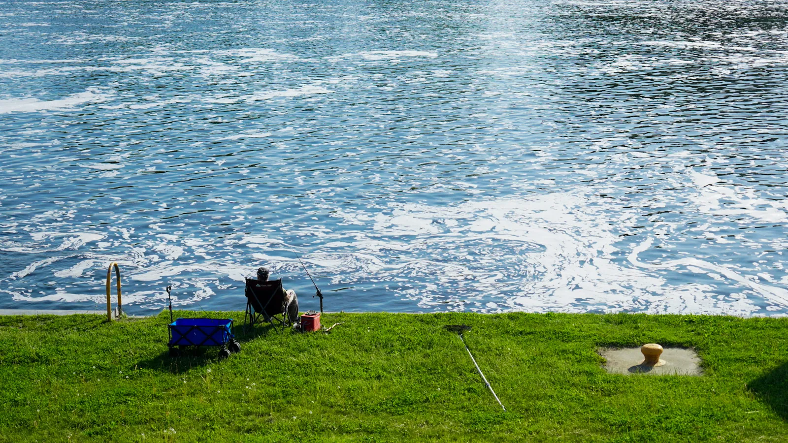 A lone angler on a river bank